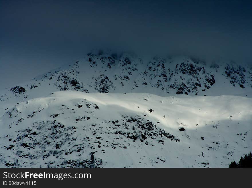 Fog and sun in the alps near a summit