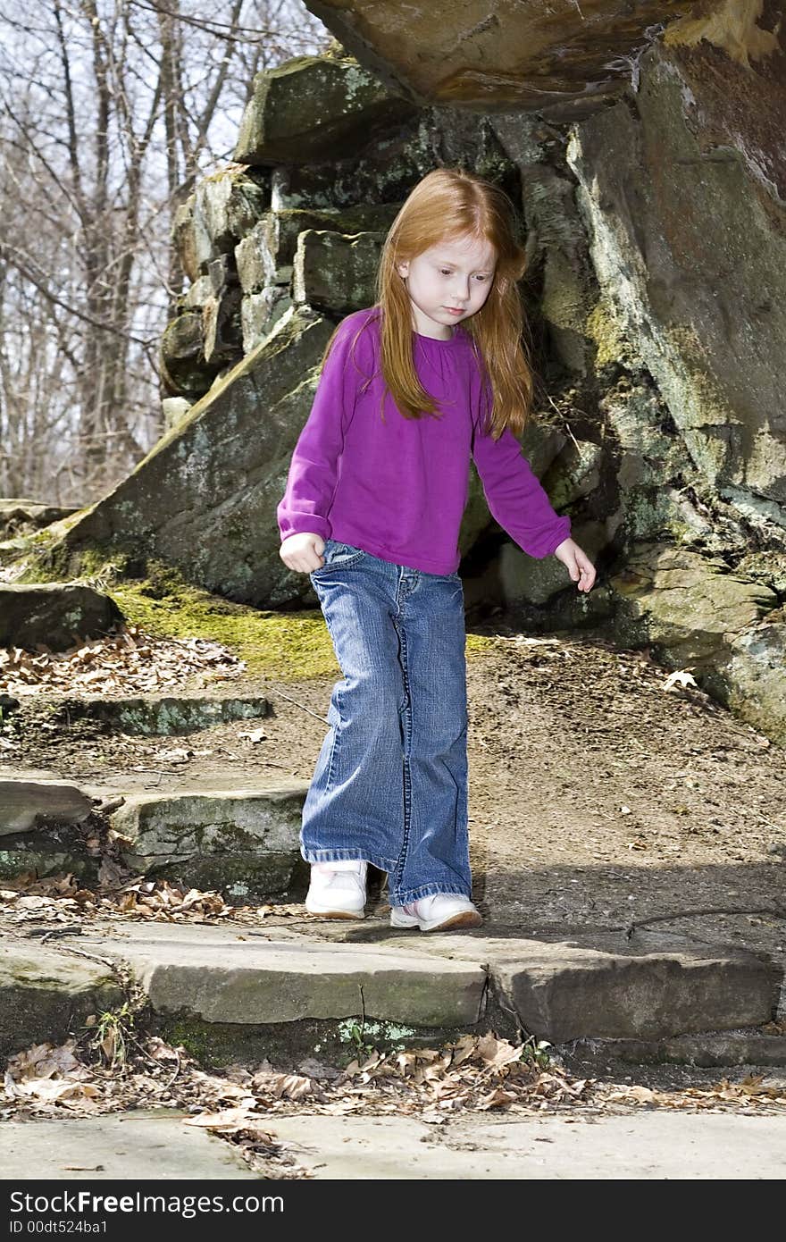 A small red-head girl explores a new park in the spring. A small red-head girl explores a new park in the spring.