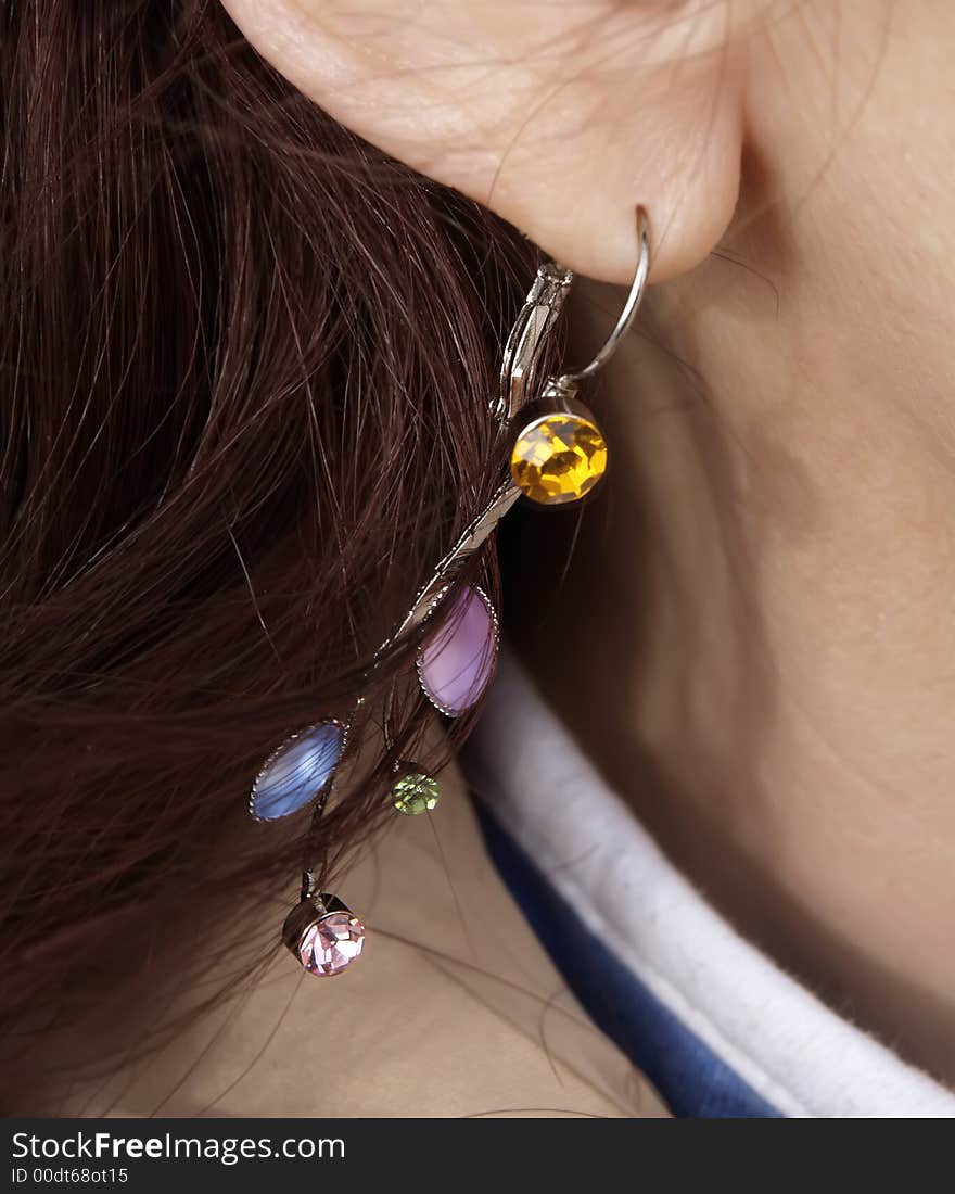 Dangling jeweled earring being worn.