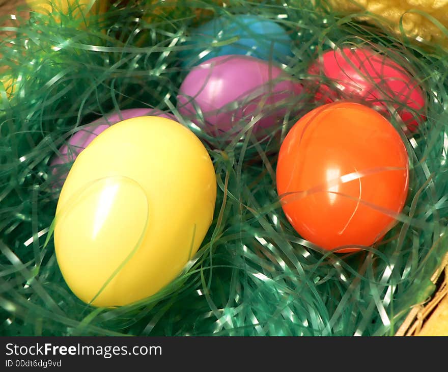 Close up photo of plastic easter eggs lying on fake grass in a Easter Basket. Close up photo of plastic easter eggs lying on fake grass in a Easter Basket