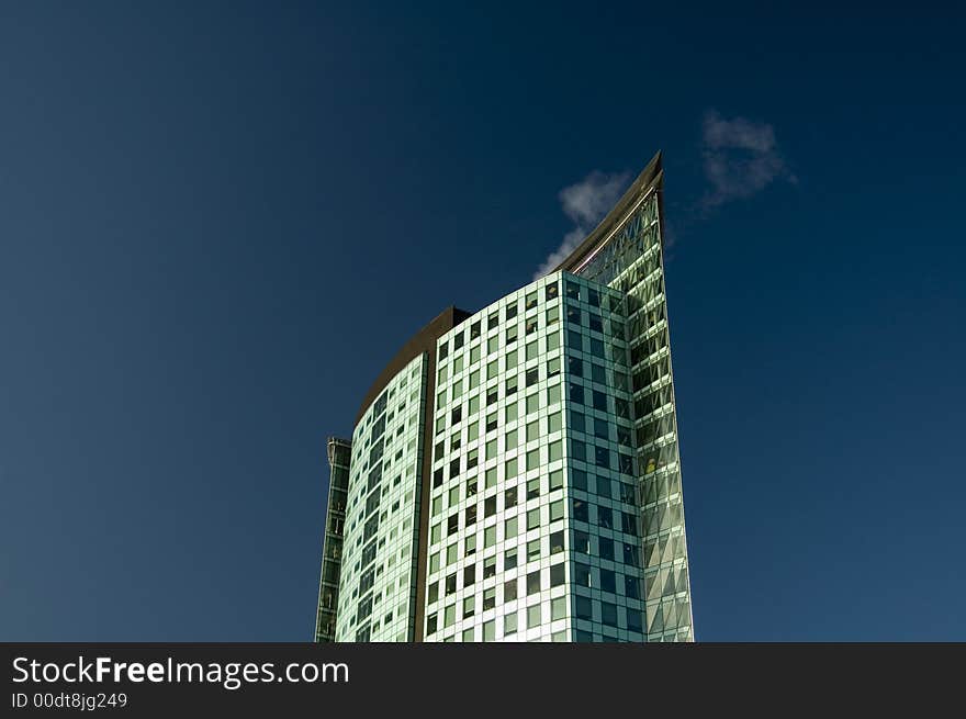 Modern office tower set against a vivid blue sky.