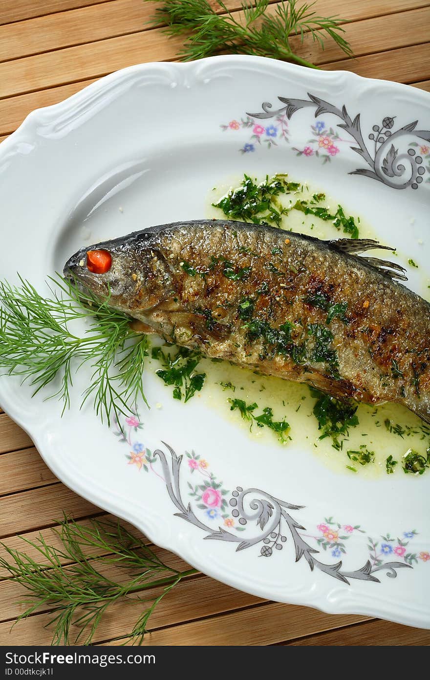 Oven fish with spice served on the white plate