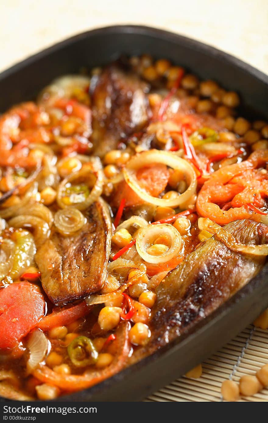 Delicious aubergine with vegetables on the black pan. Delicious aubergine with vegetables on the black pan