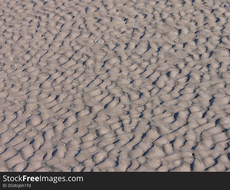 Dark sand with wave marks from the sea. Dark sand with wave marks from the sea