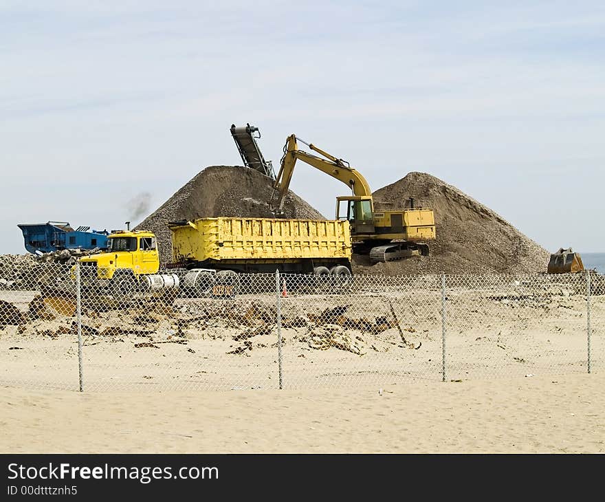 Heavy construction equipment on a work site near a beach. Heavy construction equipment on a work site near a beach.