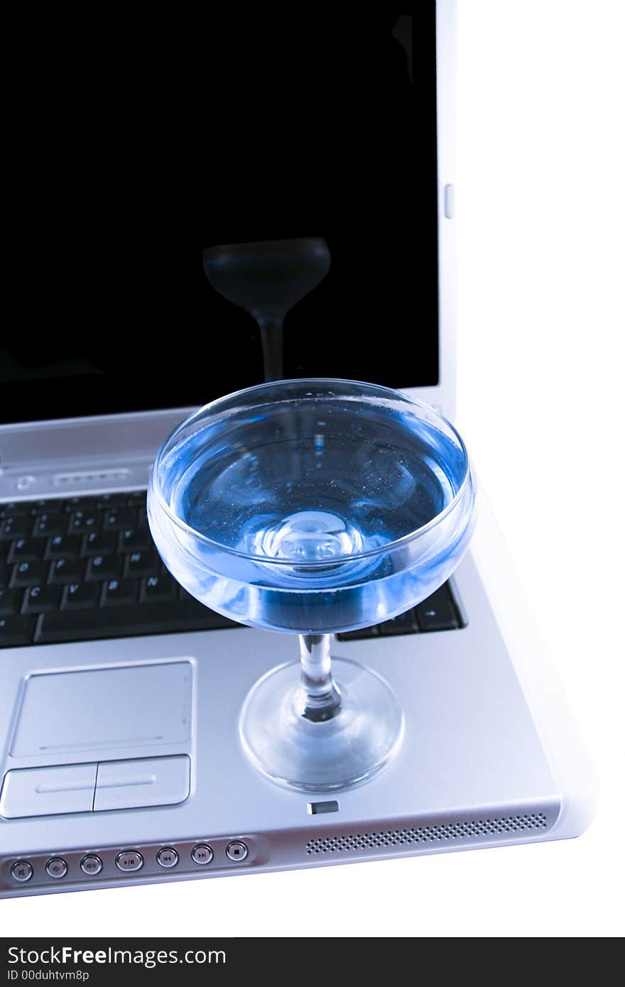 Laptop and a glass with a blue cocktail selected on a white background