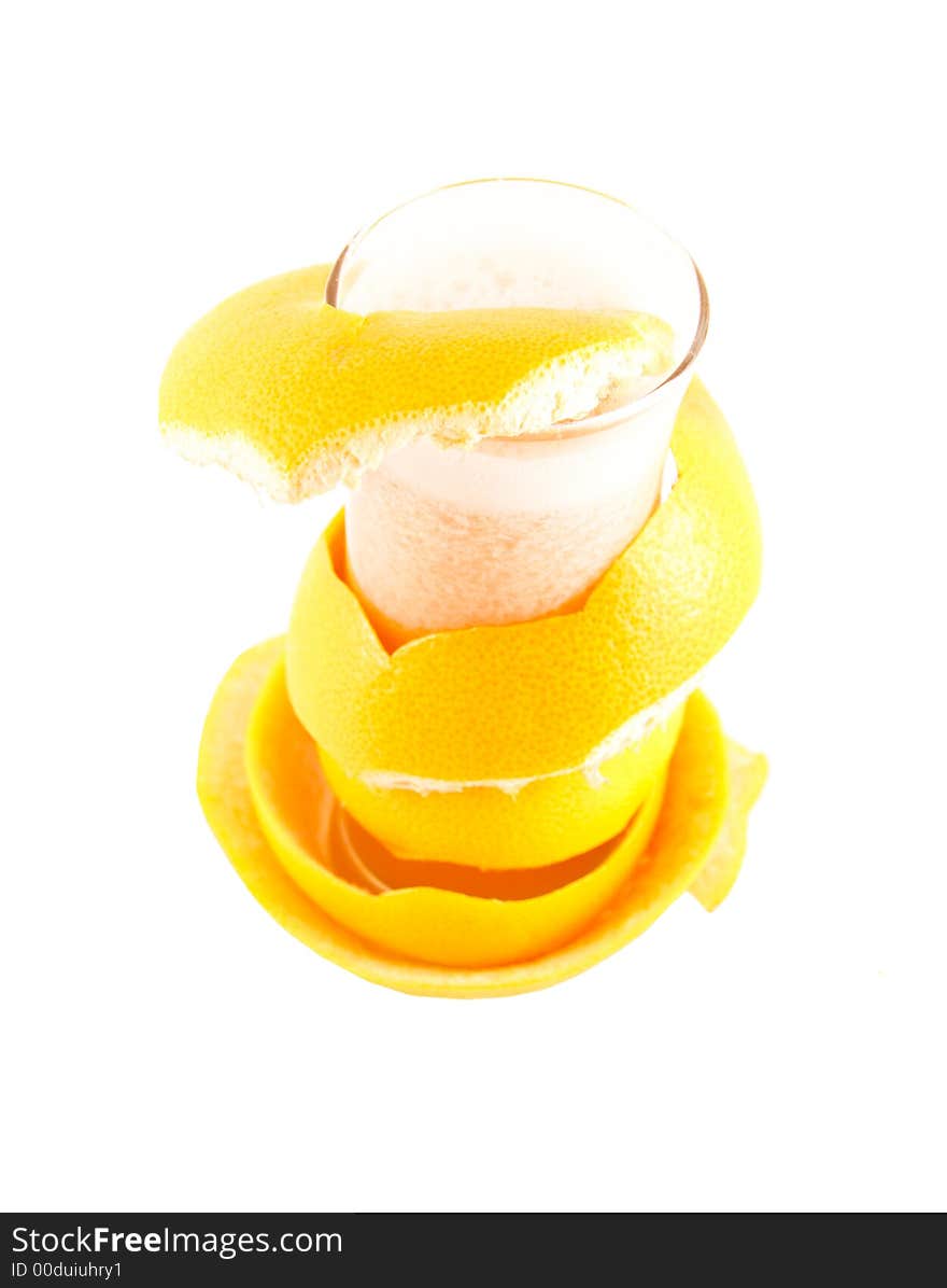 Glass with juice and a grapefruit peel selected on a white background