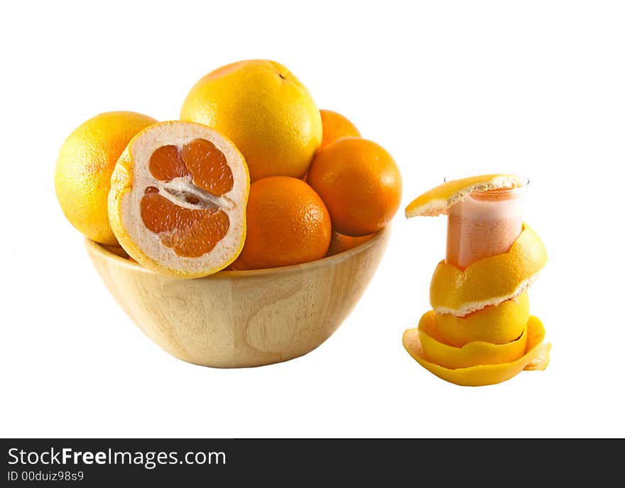 Glass with juice, grapefruit peel and a basket full of fruits selected on a white background