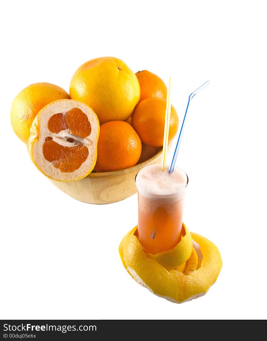 Glass with juice, grapefruit peel and a basket full of fruits selected on a white background