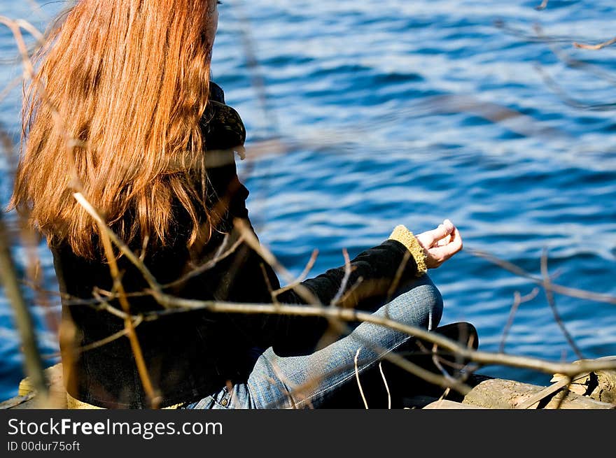 Woman at yoga pose at the lake