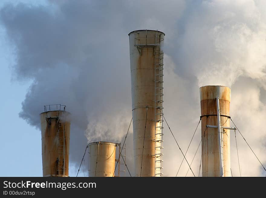 The chimney of a factory with white smoke. The chimney of a factory with white smoke