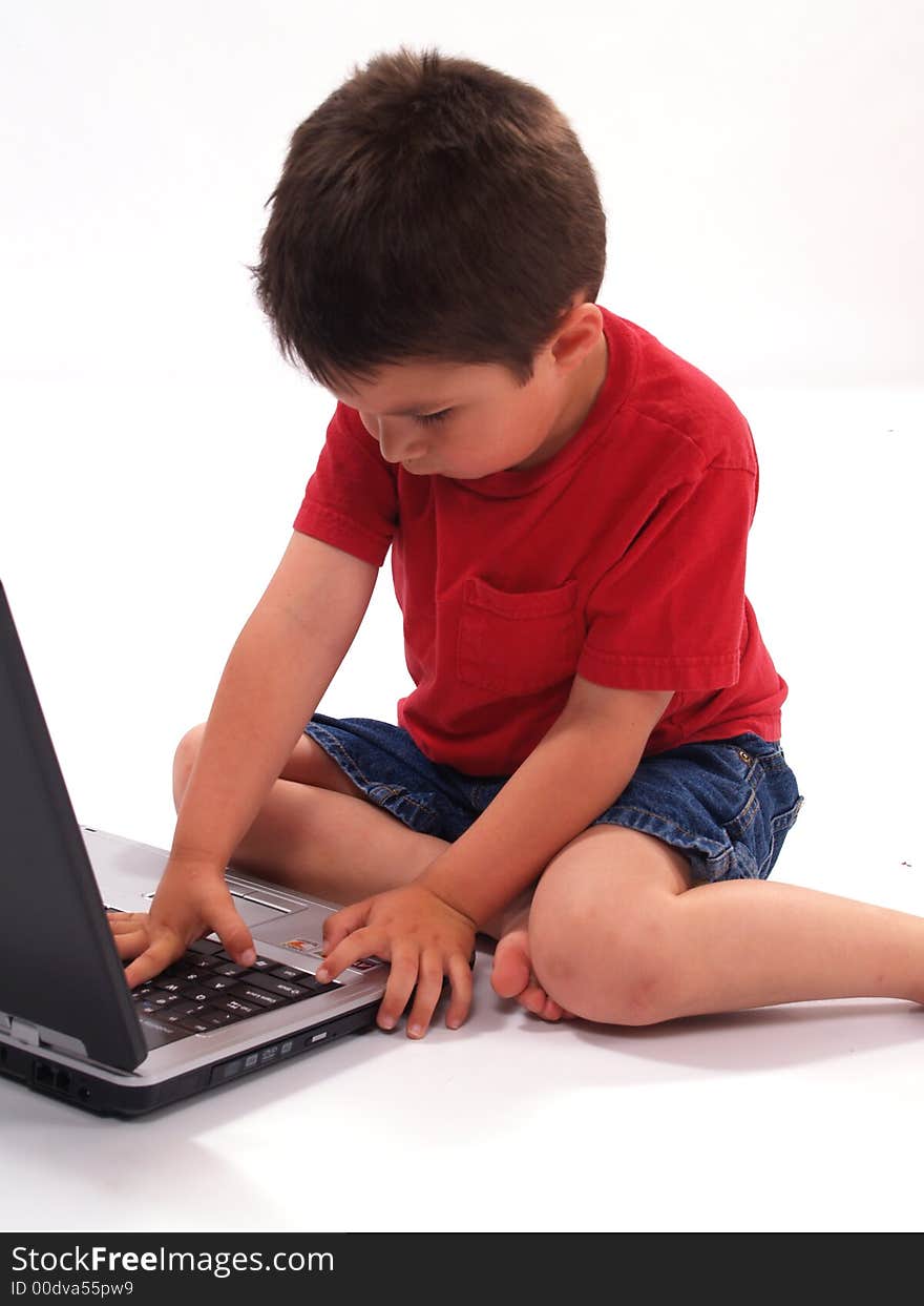 Hispanic little boy looking at a laptop. Hispanic little boy looking at a laptop