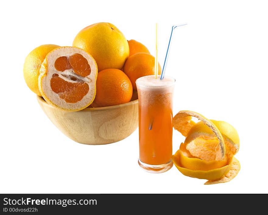 Glass with juice, grapefruit peel and a basket full of fruits selected on a white background