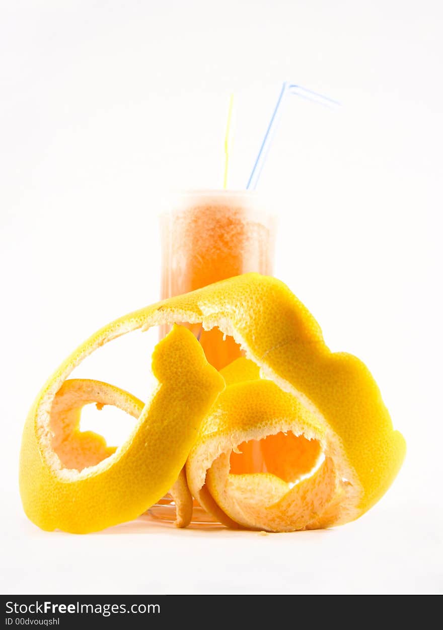 Glass with juice and a grapefruit peel selected on a white background