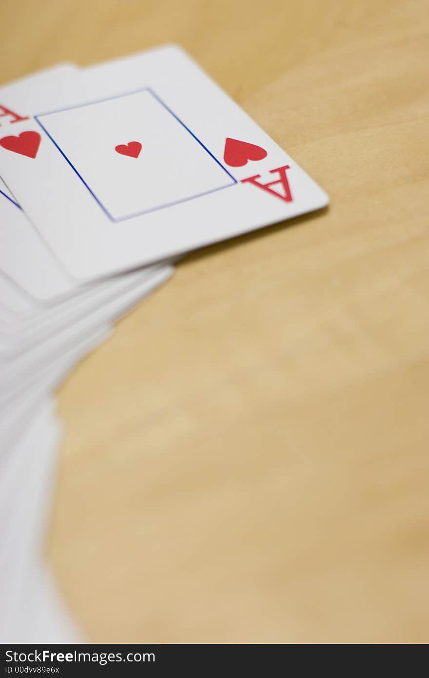 Deck of cards spread out on a wooden table with the Ace of Hearts side up. Deck of cards spread out on a wooden table with the Ace of Hearts side up