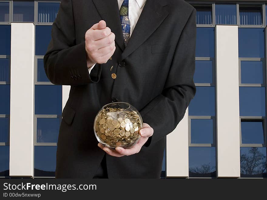 Business man with a glass sphere which include a lot of coins. Business man with a glass sphere which include a lot of coins