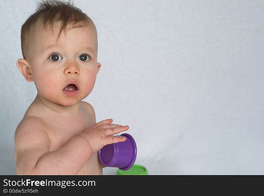 Image of adorable baby playing with stacking cups. Image of adorable baby playing with stacking cups