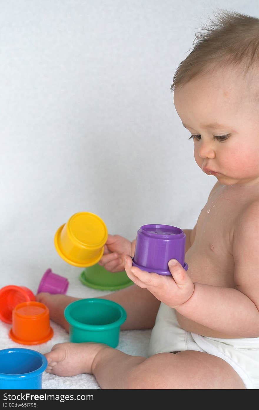 Image of adorable baby playing with stacking cups. Image of adorable baby playing with stacking cups