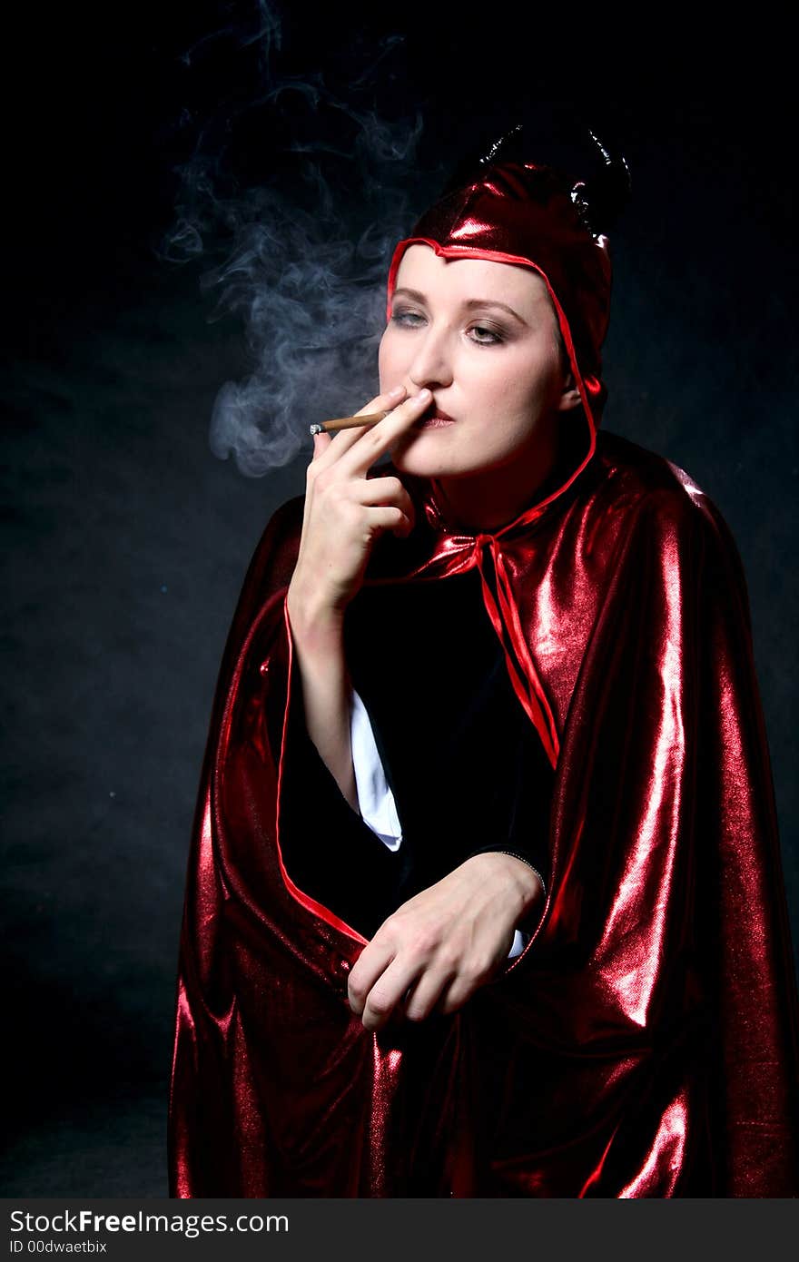 Smoking women in devil costume. Make-up black background. Smoking women in devil costume. Make-up black background.