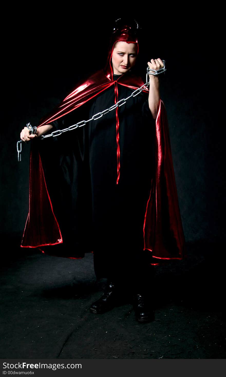 Women in devil costume with chain in hands. Make-up black background. Women in devil costume with chain in hands. Make-up black background.