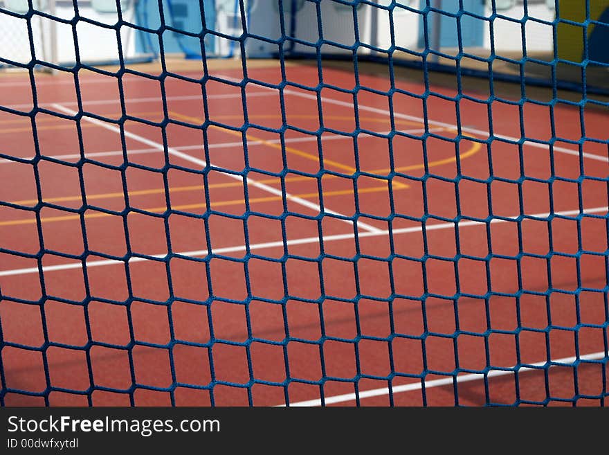 Blue rope fence in focus with basketball court in background. Blue rope fence in focus with basketball court in background