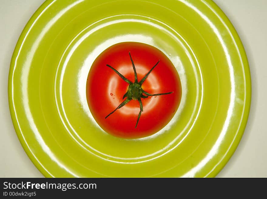 Red tomato on green plate