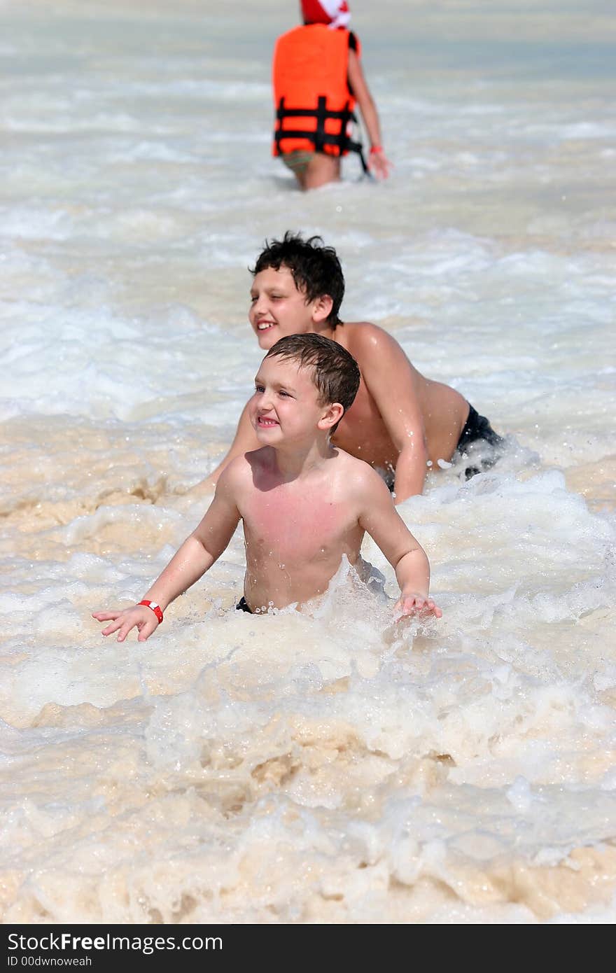 Two boys enjoying the ocean surf during playtime. Two boys enjoying the ocean surf during playtime