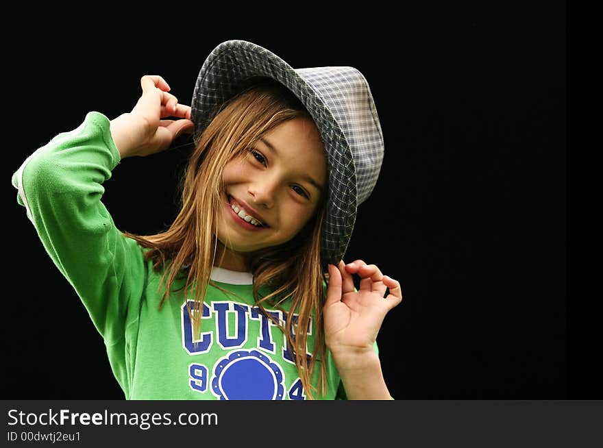 Cute teenager holding her hat and twisting her head to side with big smile. Cute teenager holding her hat and twisting her head to side with big smile