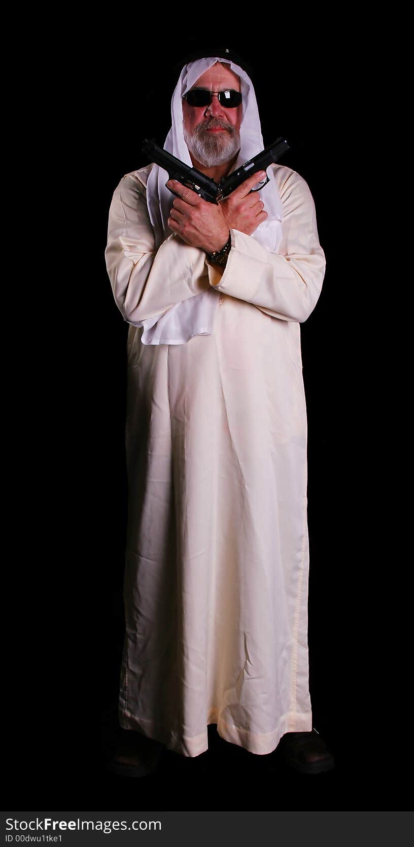 Middle east man holding two guns on his chest with black background. Middle east man holding two guns on his chest with black background