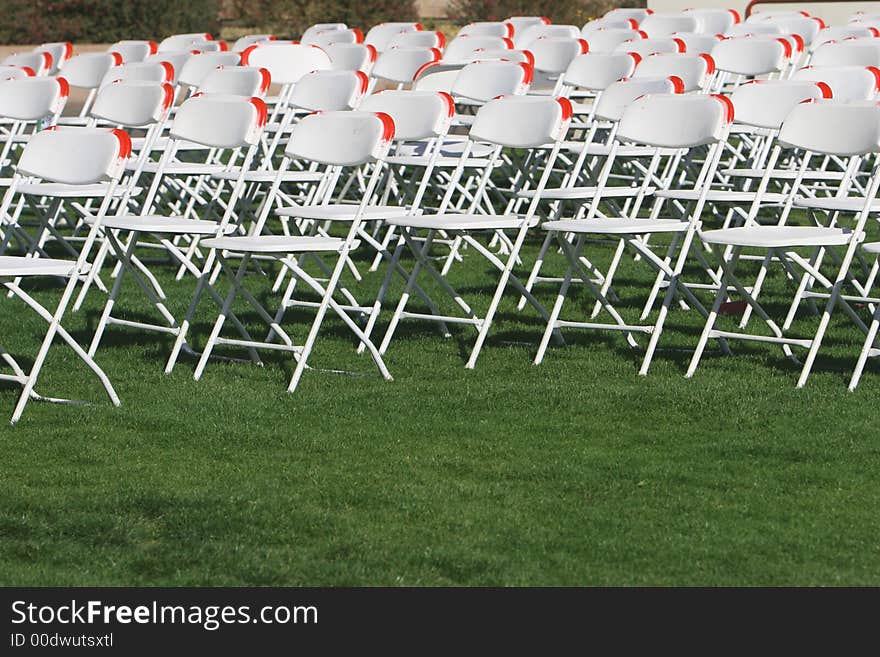 Folding Chairs set up on a green lawn for an event. Folding Chairs set up on a green lawn for an event.