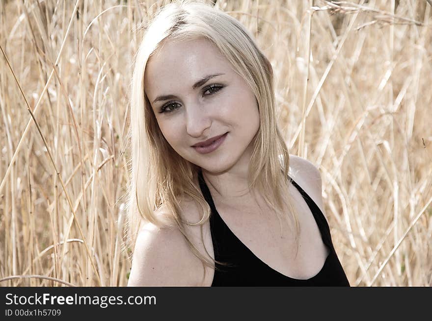 Portrait of a blonde woman with green eyes smiling, on a sunny day. Soft sepia image color. Portrait of a blonde woman with green eyes smiling, on a sunny day. Soft sepia image color