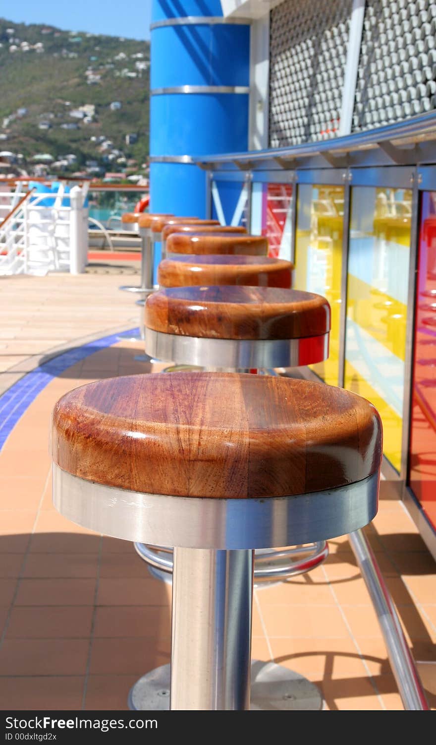 A row of barstools around colorful ships bar. A row of barstools around colorful ships bar