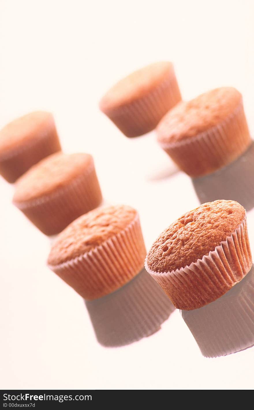 Five packed fruitcakes lay on surface of table on white background