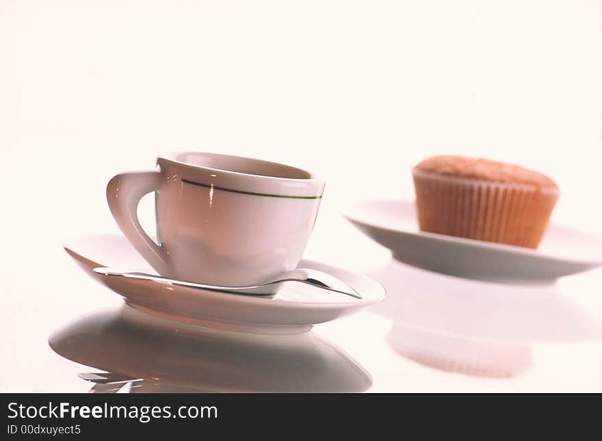 Small cup of coffee with  spoon in  plate and plate with  fruitcake on  white background