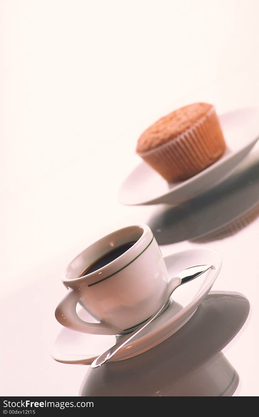 Small cup of coffee with the spoon in  plate and  plate with  fruitcake on  white background. Small cup of coffee with the spoon in  plate and  plate with  fruitcake on  white background