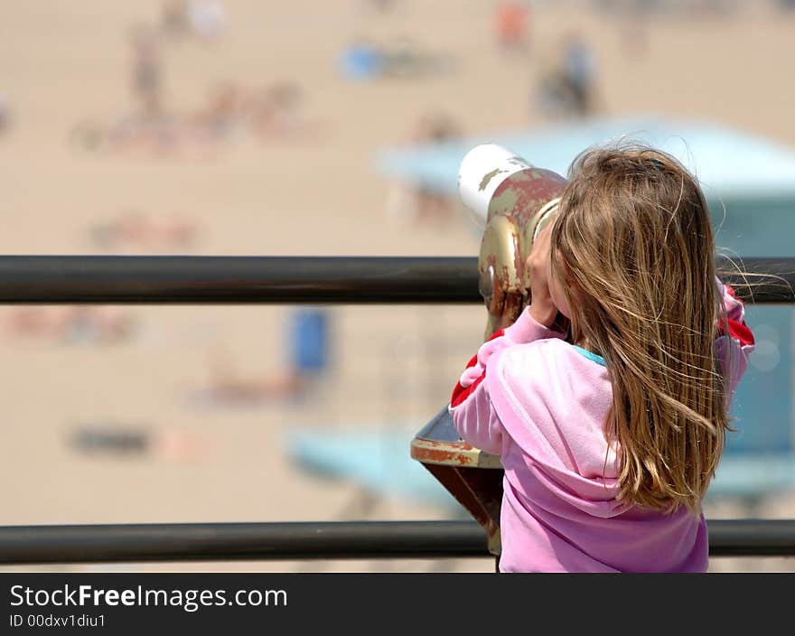 Little Girl Enjoys View of Beach Through Telescope. Little Girl Enjoys View of Beach Through Telescope