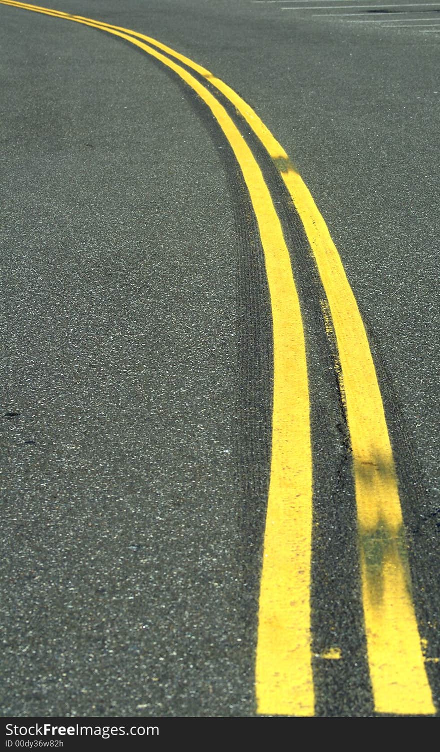 A curved double yellow line freshly painted