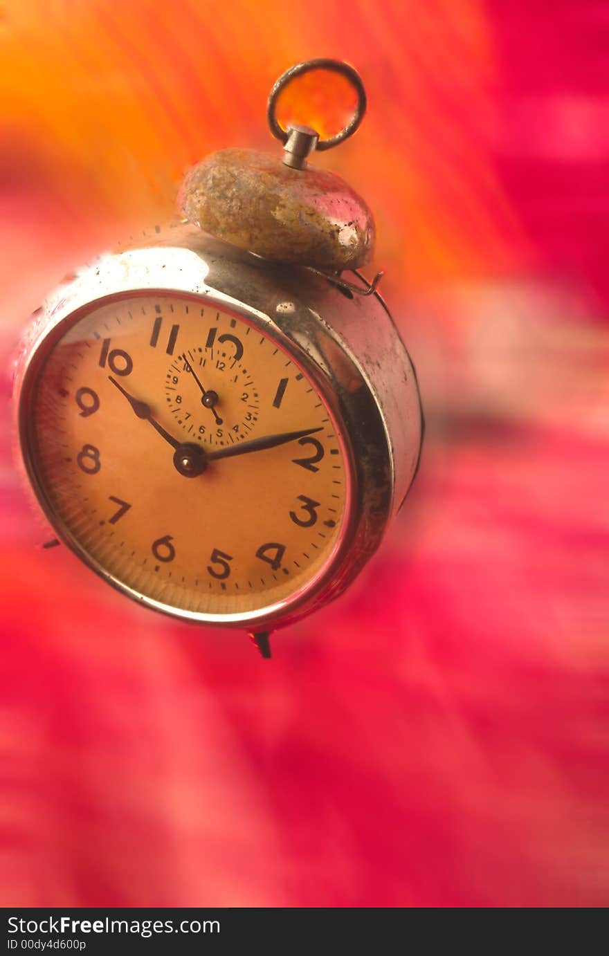 Hours -  alarm clock is located on  red dynamical background