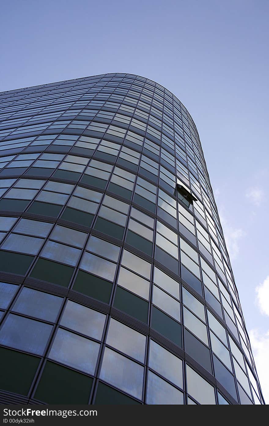 Glass office building with sky and clouds in the background. Glass office building with sky and clouds in the background