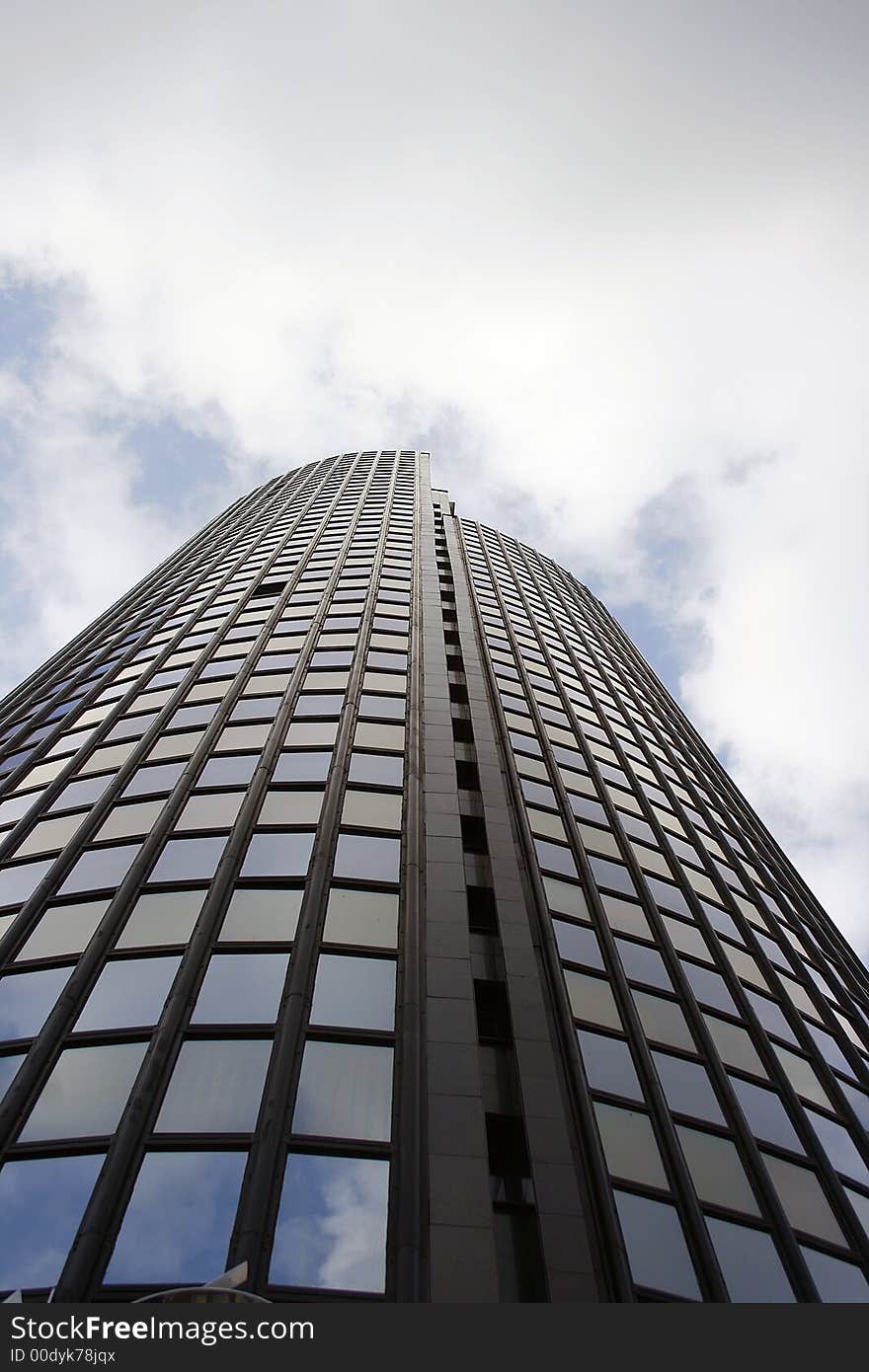 Glass office building with sky and clouds in the background. Glass office building with sky and clouds in the background