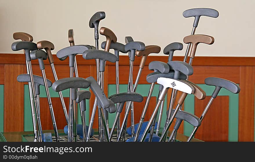 Golf putters sticking out of a rack