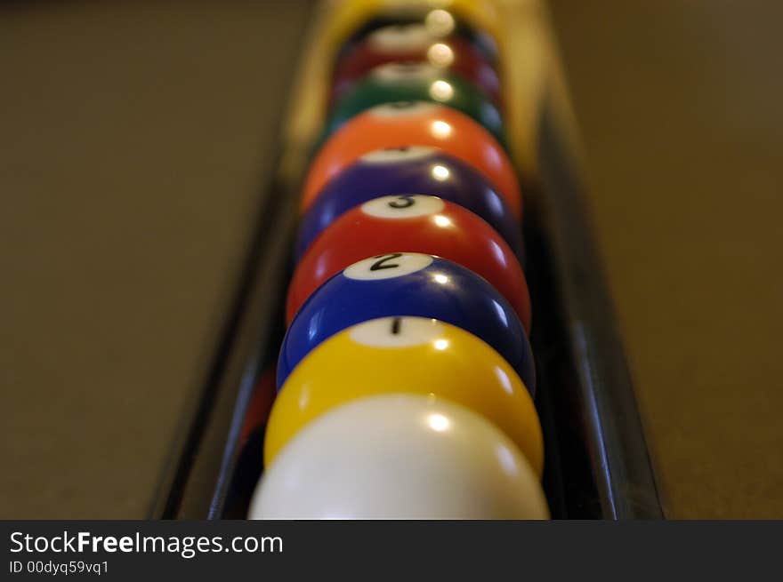 A set of pool balls sitting on some pool sticks.