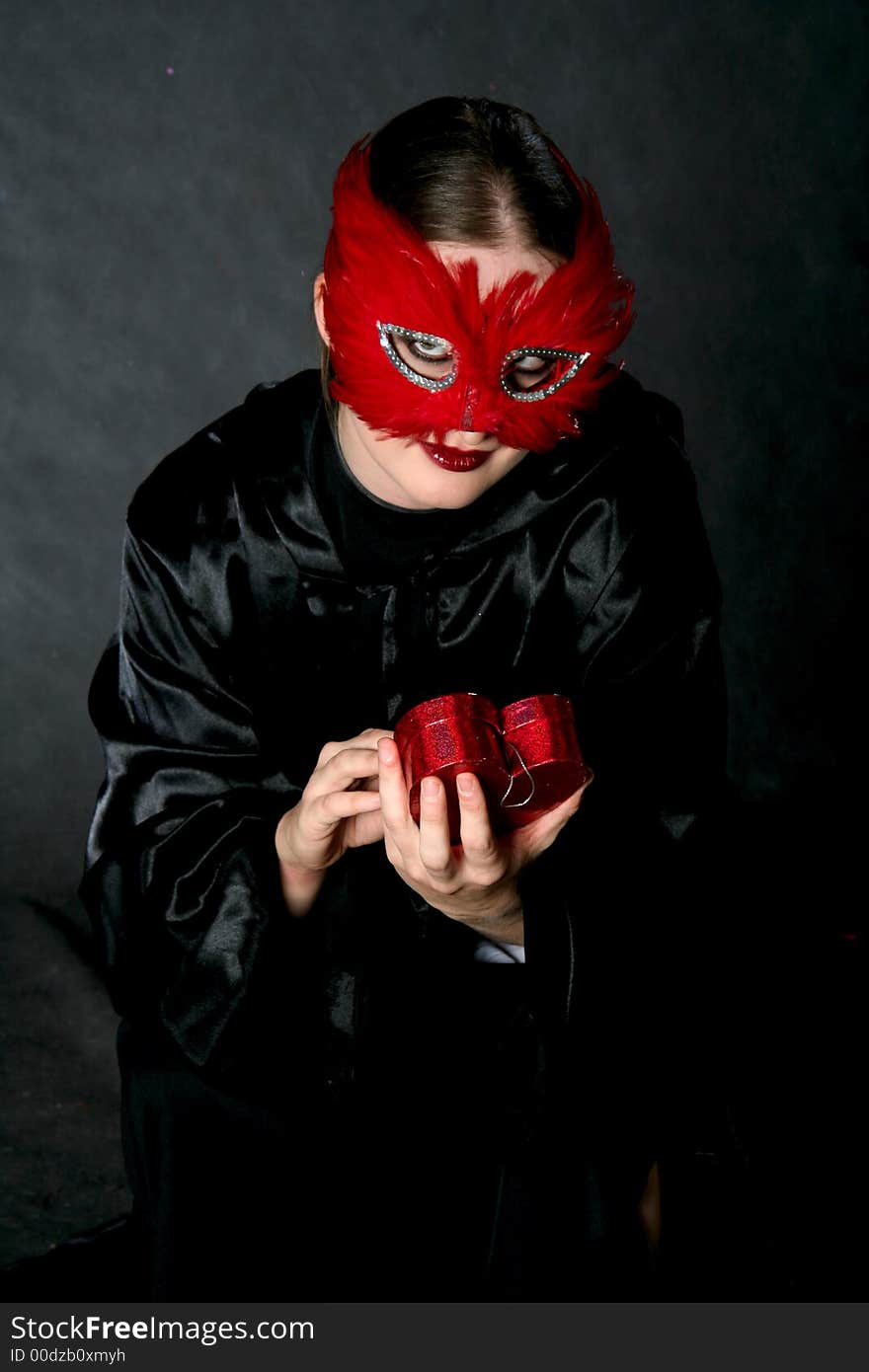 Women in red mask with heart. Make-up black background. Women in red mask with heart. Make-up black background.