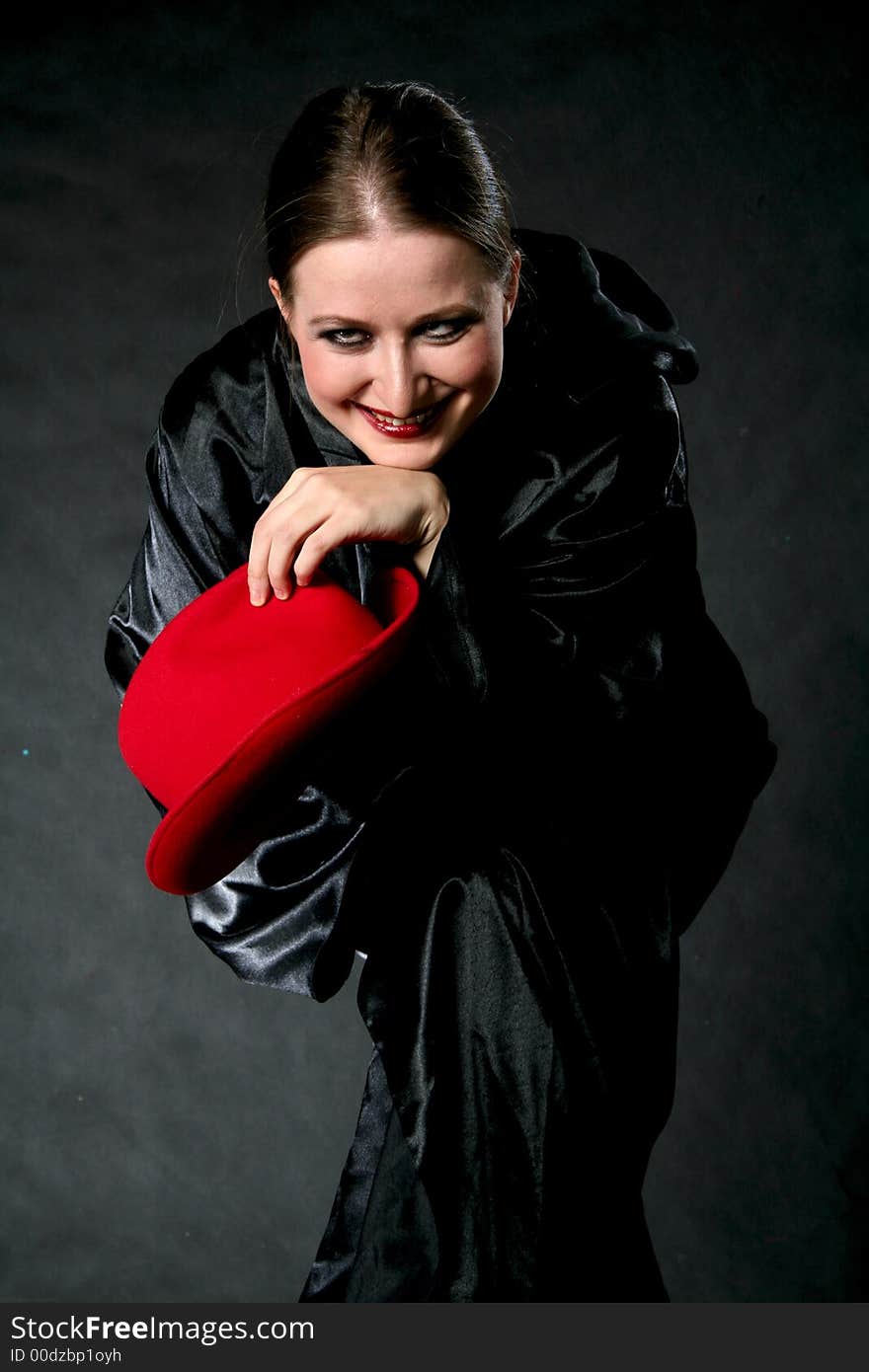 Smiling women with red hat in hand. Make-up retro black background. Smiling women with red hat in hand. Make-up retro black background.