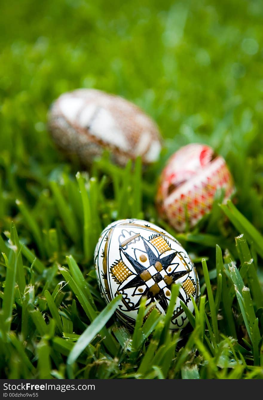 Three hand painted Easter Eggs on bright dew covered grass.  Shallow depth of field, copy space available. Three hand painted Easter Eggs on bright dew covered grass.  Shallow depth of field, copy space available