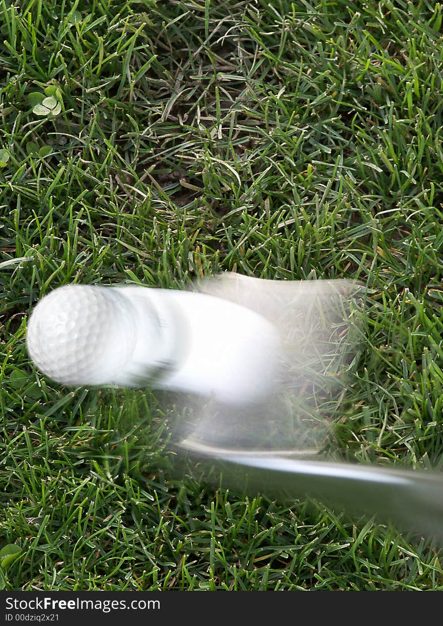 Close-up of golf ball launches off of 9-iron from rough. Close-up of golf ball launches off of 9-iron from rough.