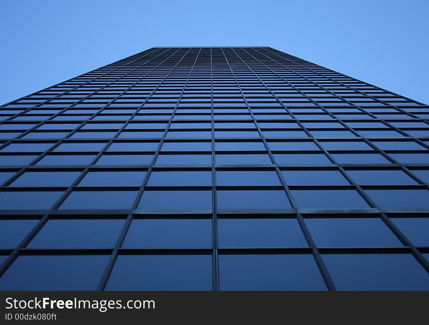 Perspective view of a blue-windowed skyscraper, directly from below. Perspective view of a blue-windowed skyscraper, directly from below.