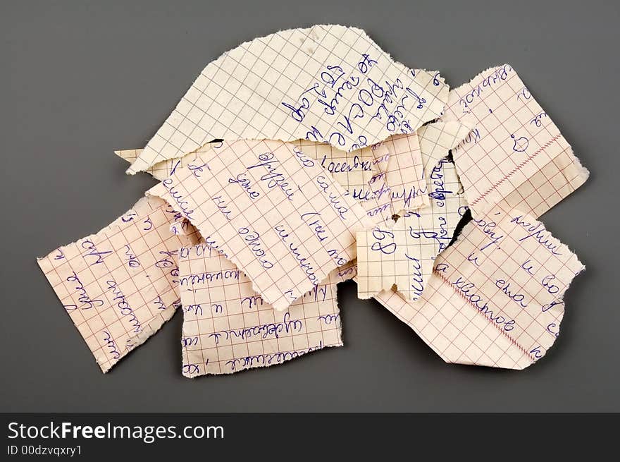 Small group of torn notebook paper isolated over grey. Small group of torn notebook paper isolated over grey