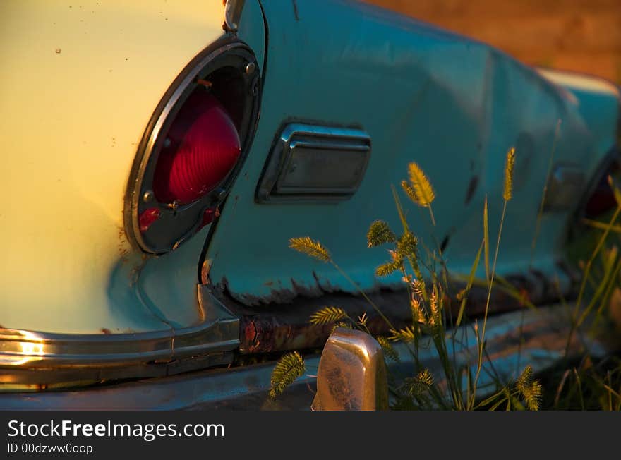 Abandoned car and farm buildings in teh american great plains.