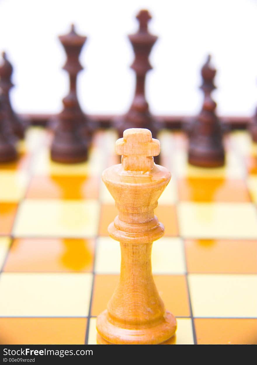 A king chess piece with others in background. A king chess piece with others in background.